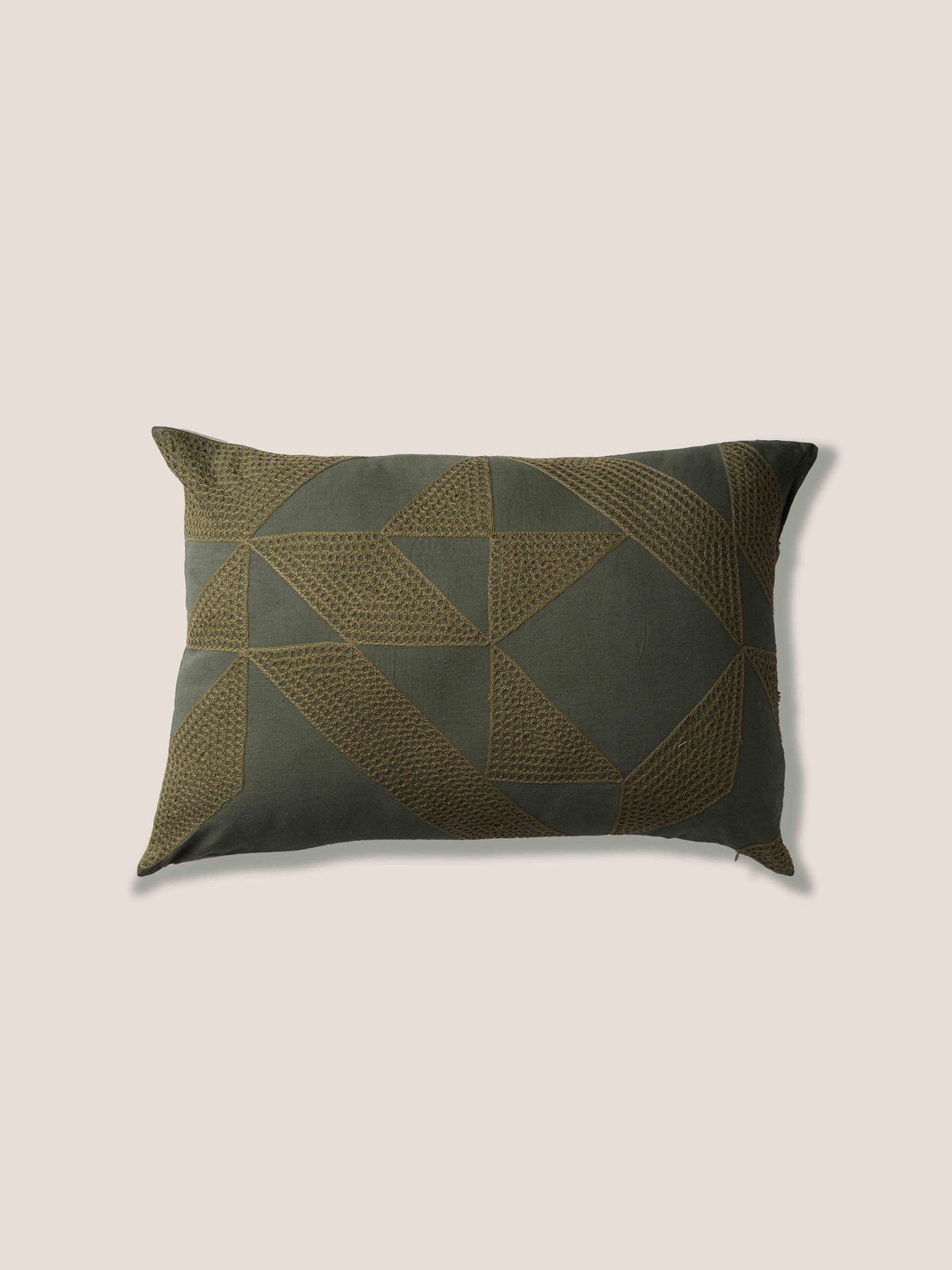 Decorative pillow with geometric pattern on a beige background