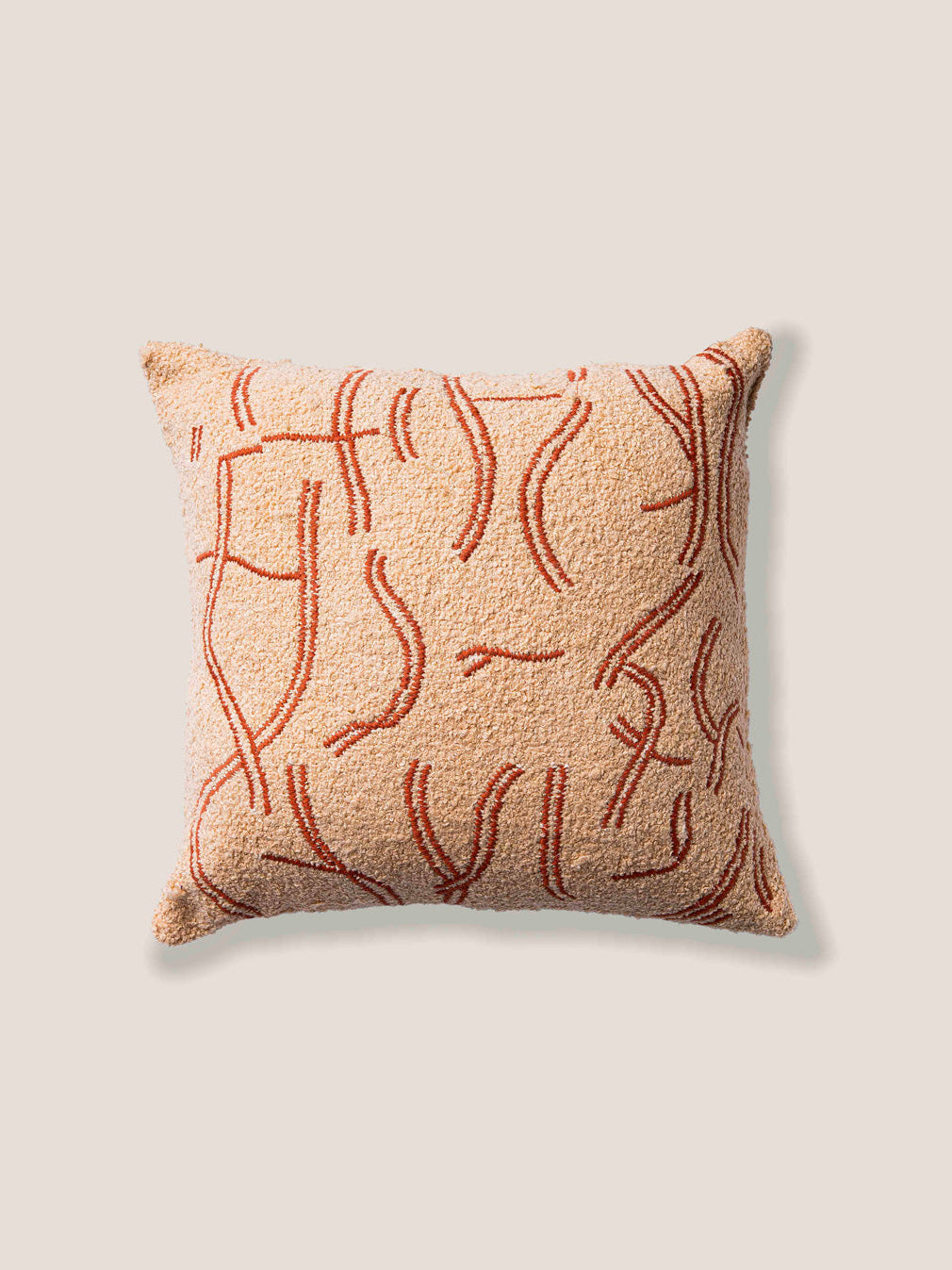 Decorative pillow with abstract red pattern on a beige background